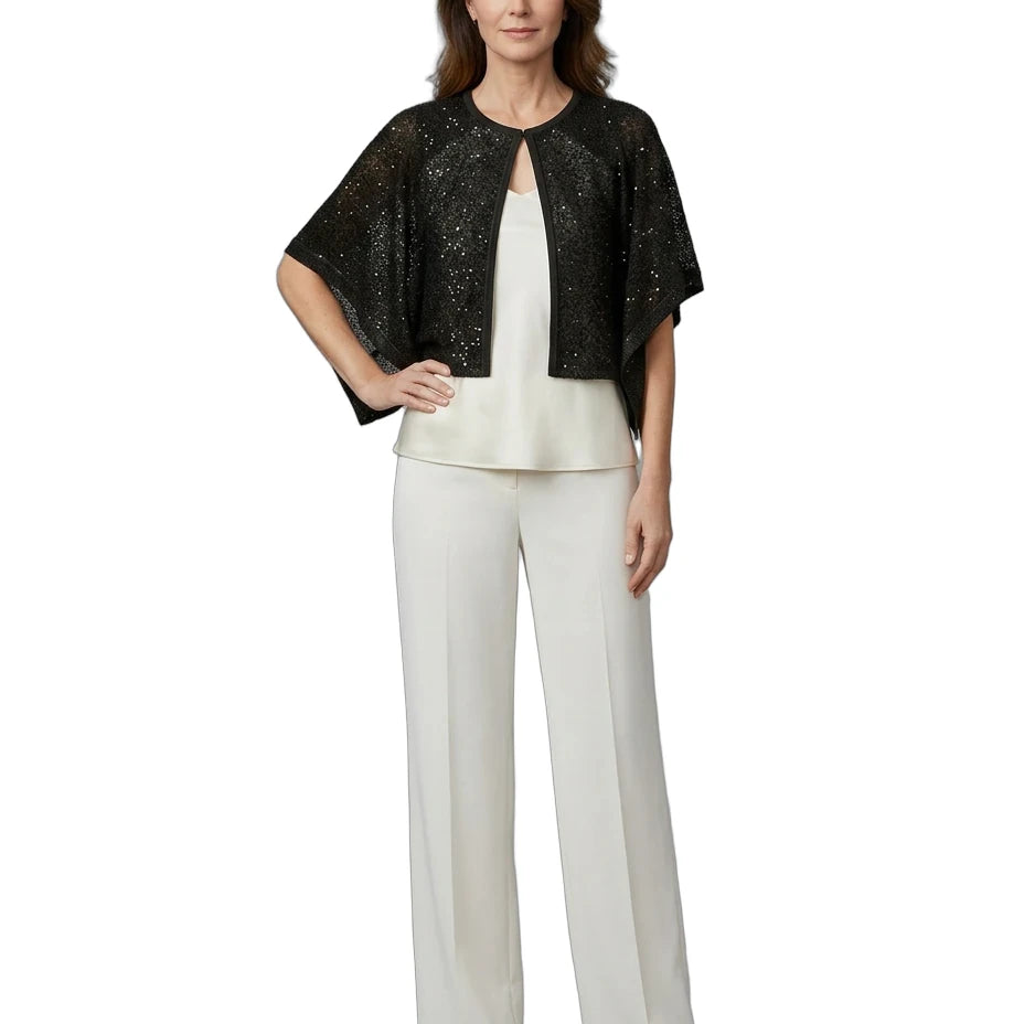Woman wearing a black sequin top and white pants on a white background