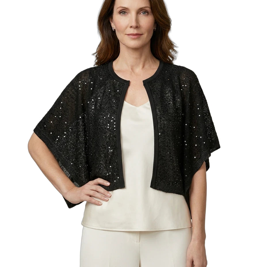Woman wearing a black sequined jacket over a white top and pants on a white background