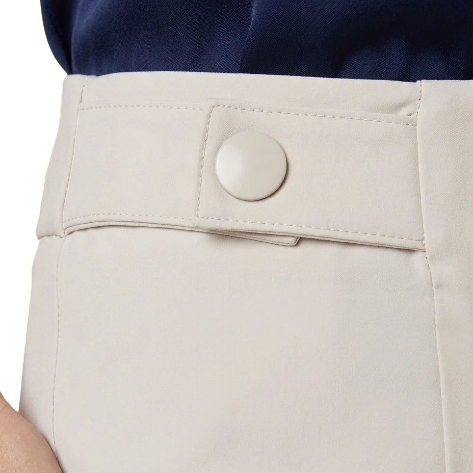 Close-up of a person wearing light beige trousers with a buttoned waistband and a navy top, cropped to show the waist area.