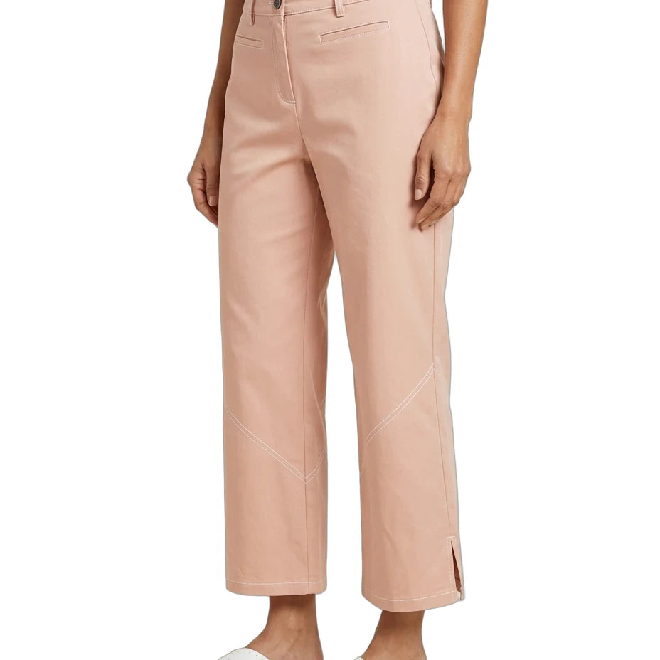 A model wearing light peach-pink cropped trousers with diagonal seam details on the lower legs, styled with a dark gray top and white slide sandals against a plain white background.