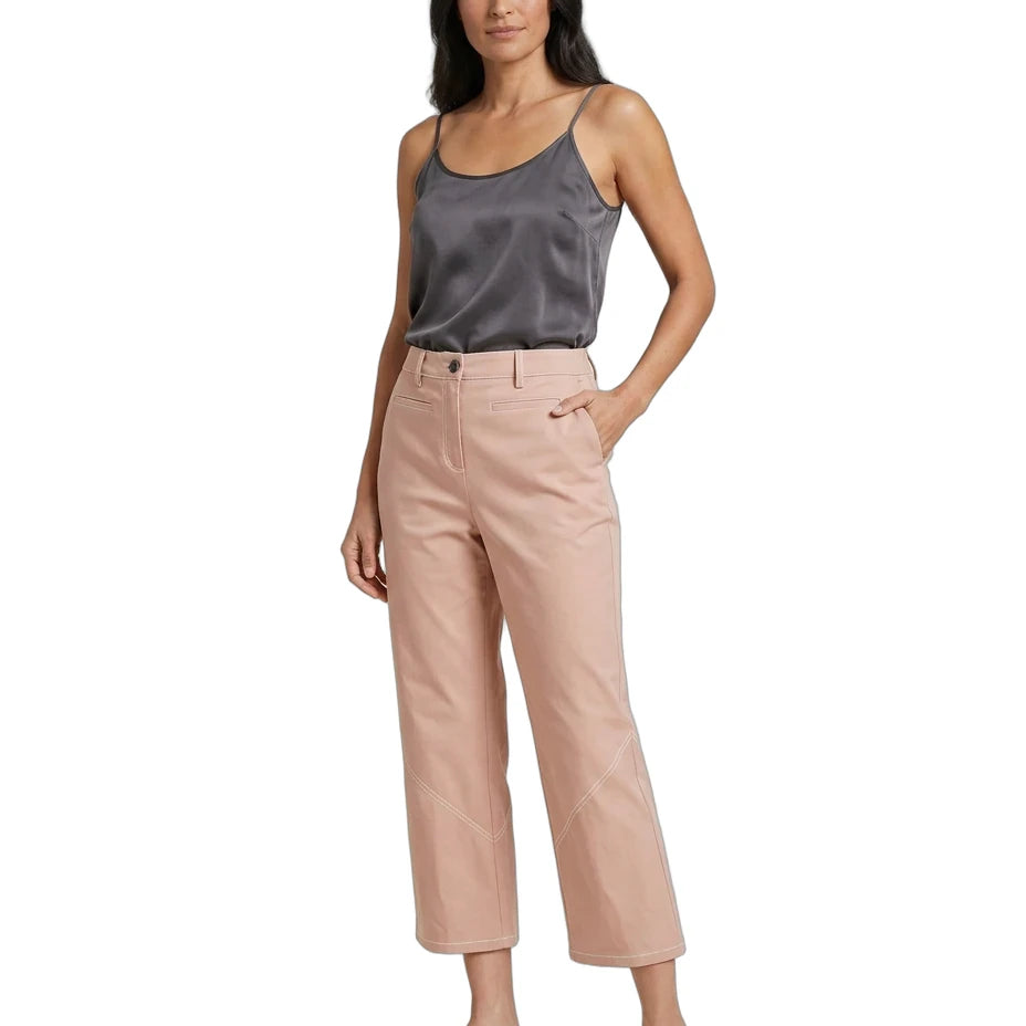 A woman modeling a pair of light blush pink cropped pants with a dark gray satin camisole and white slide sandals, set against a plain white background.