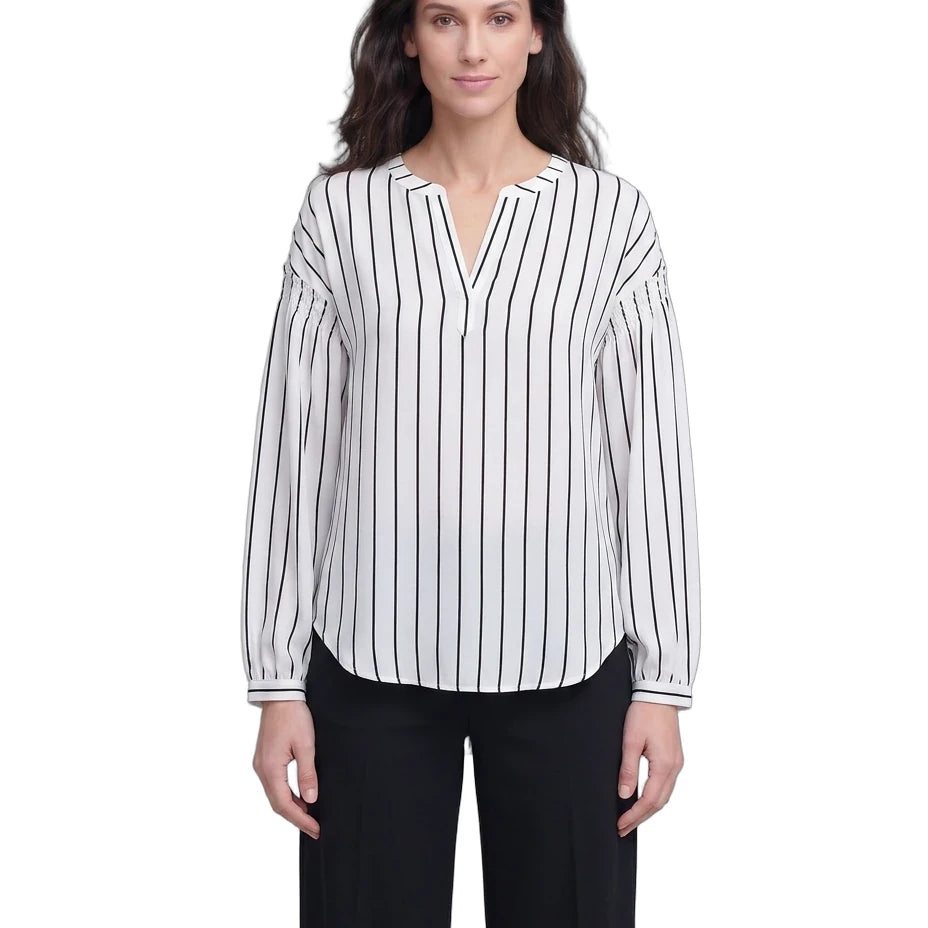Woman wearing a black and white striped blouse with a plain background