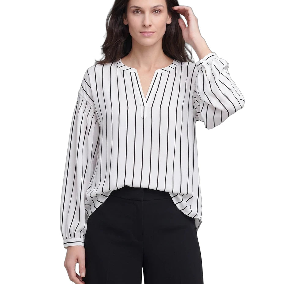 Woman wearing a black and white striped blouse with black pants on a white background