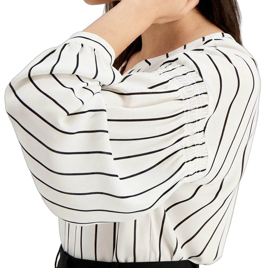 Woman wearing a white blouse with black striped pattern
