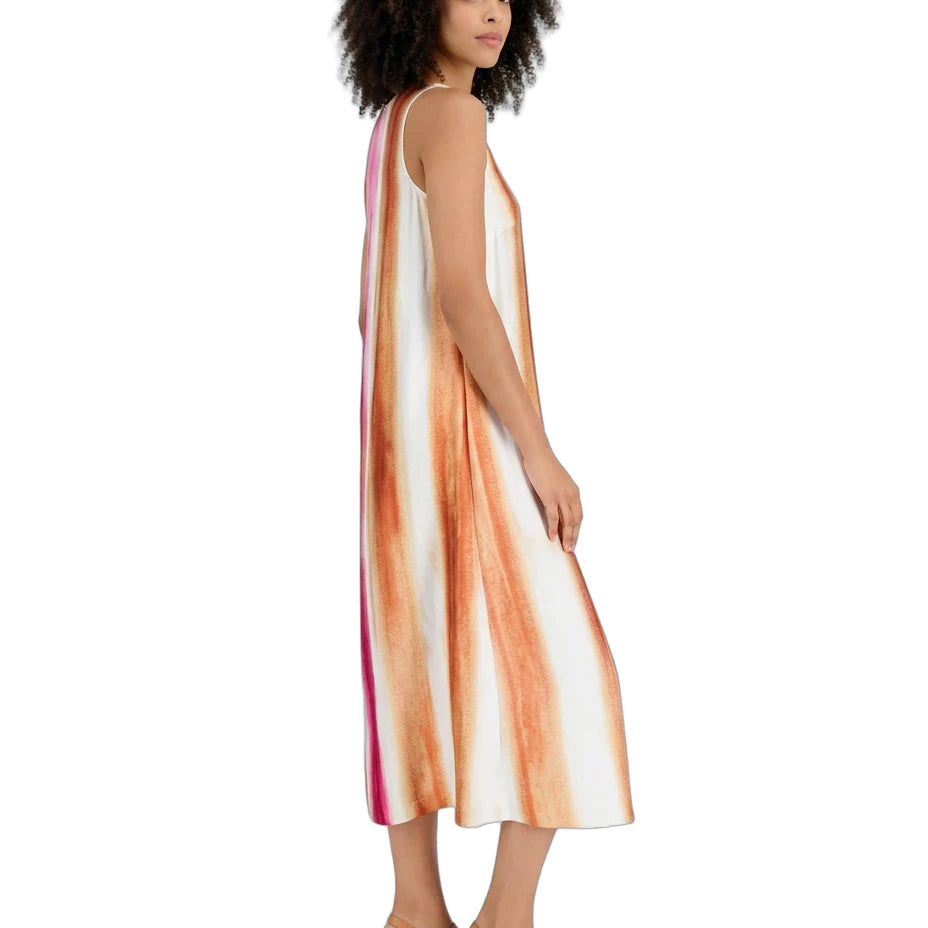 A woman modeling a sleeveless midi dress with vertical orange, peach, and pink watercolor-style stripes on a white base, shown from a side-back angle against a plain white background.