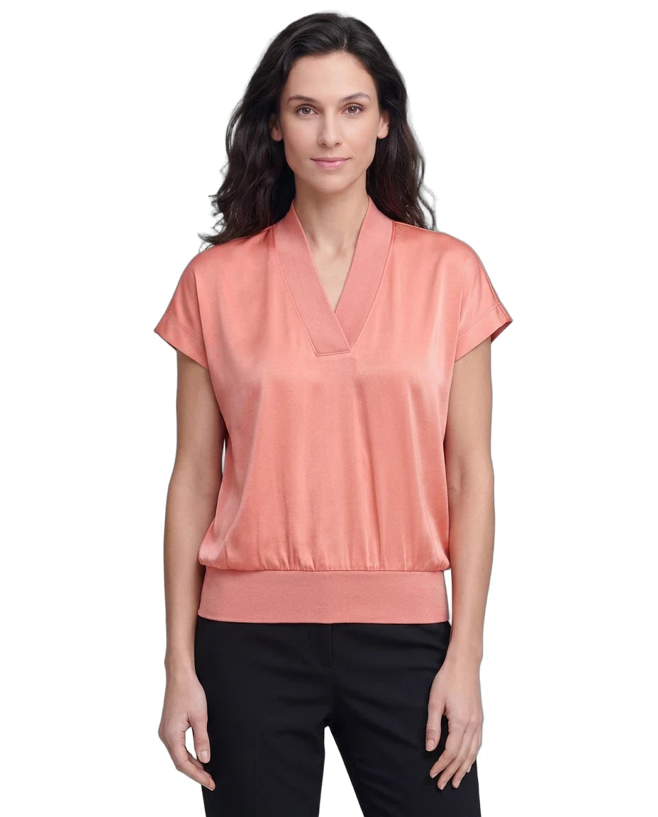 Woman wearing a coral blouse with a white background