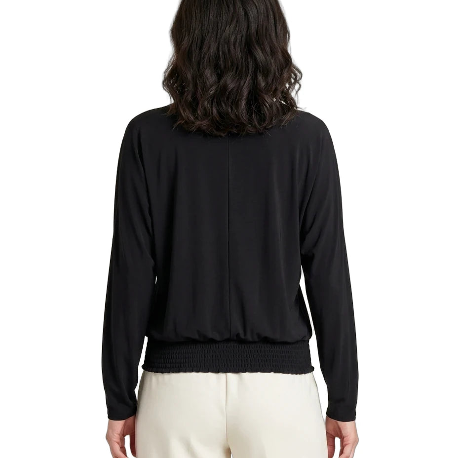 Person wearing a black long-sleeve top and white pants on a white background