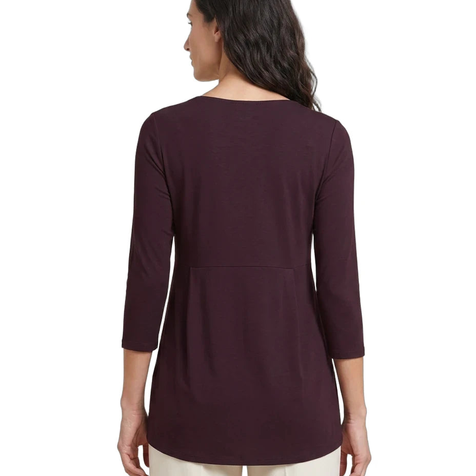 A woman shown from the back wearing a dark plum-colored three-quarter sleeve top and cream pants against a plain white background.
