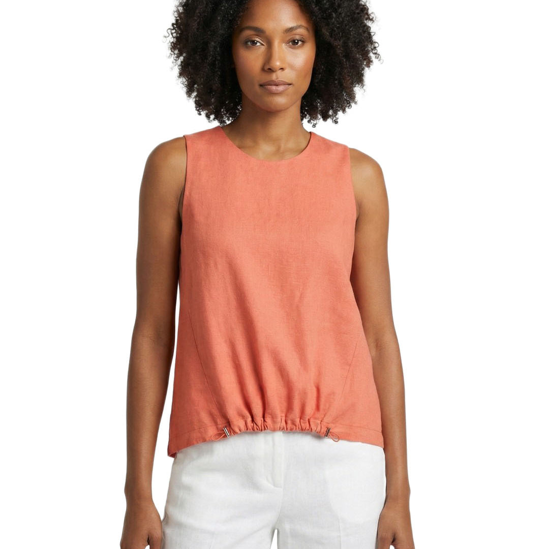 Woman wearing a coral sleeveless top and white pants on a white background