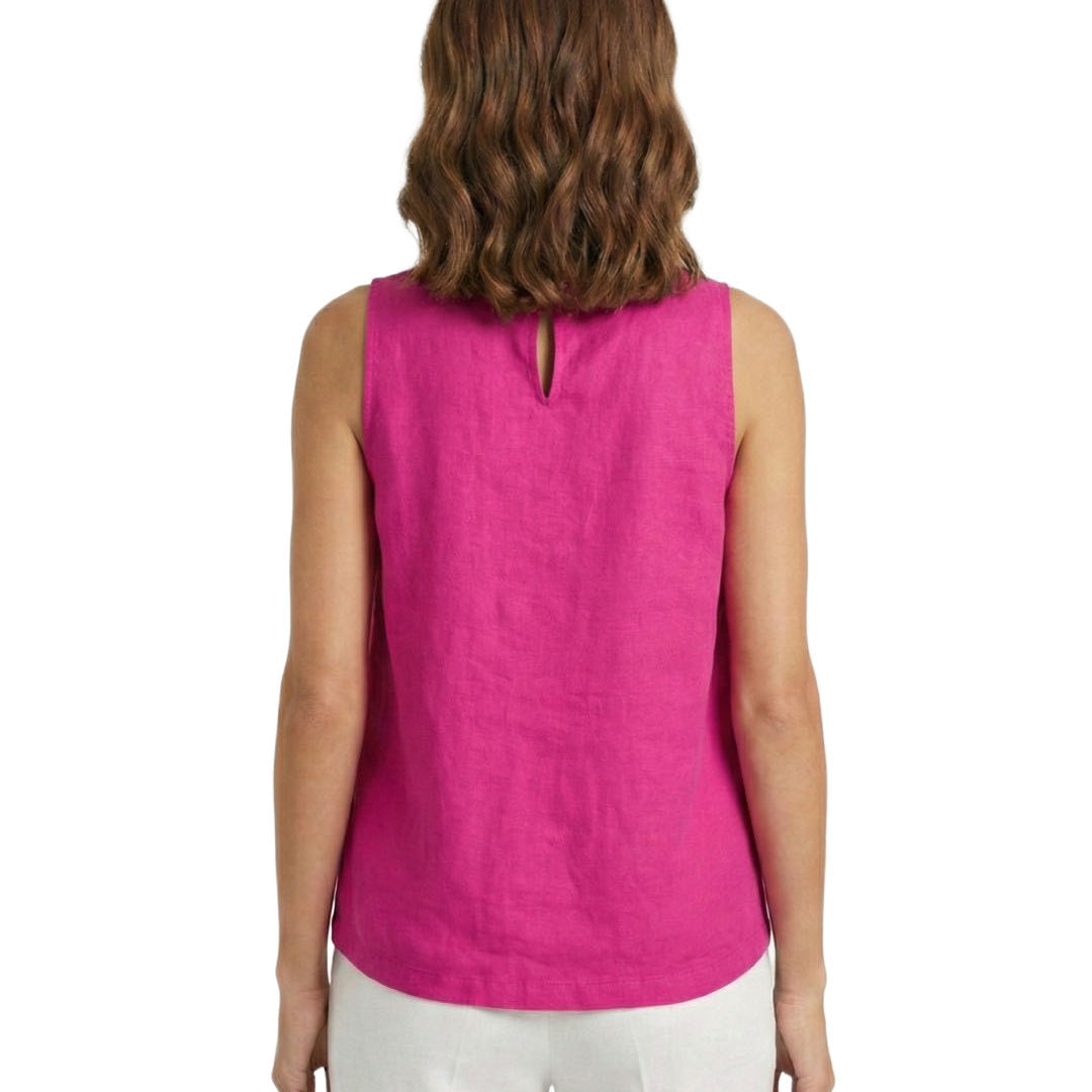 Woman wearing a pink sleeveless top and white pants on a white background