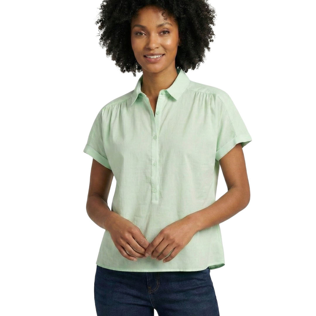 Woman wearing a light green short-sleeve blouse on a white background