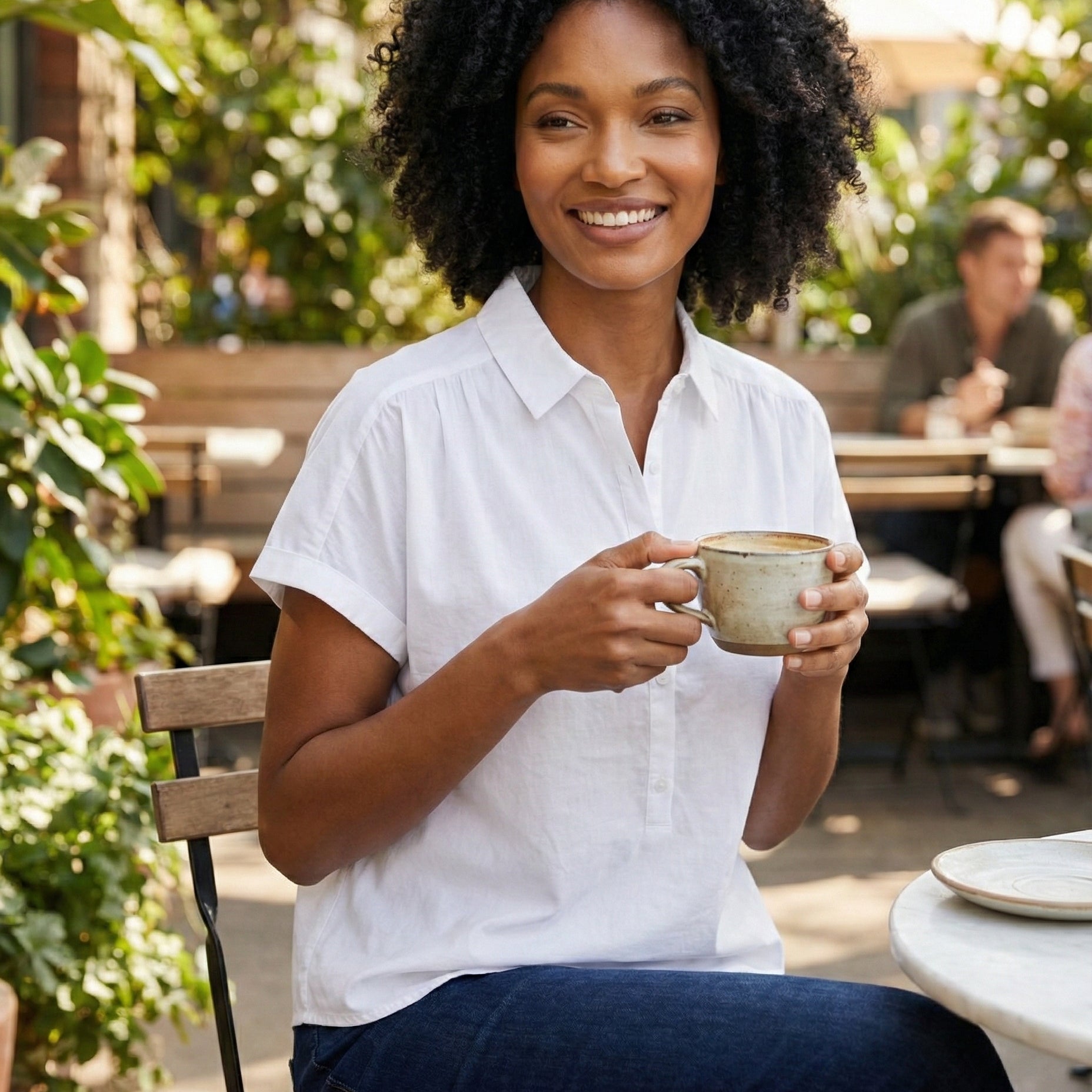 Woman holding a mug outdoors in a casual setting