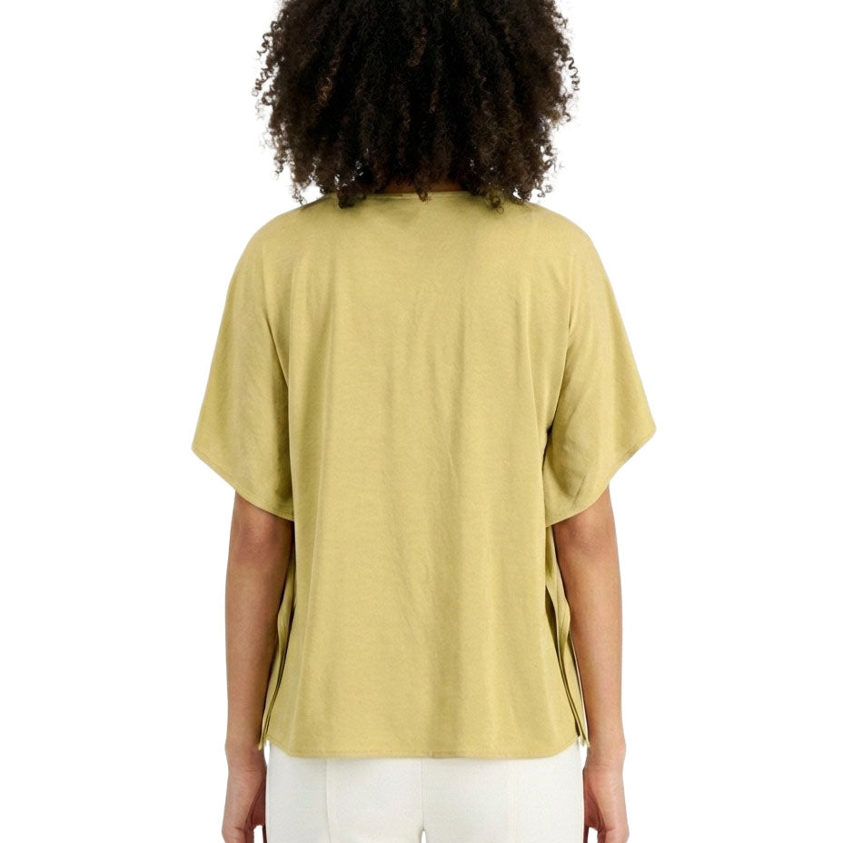 Person wearing a light green t-shirt and white pants on a white background