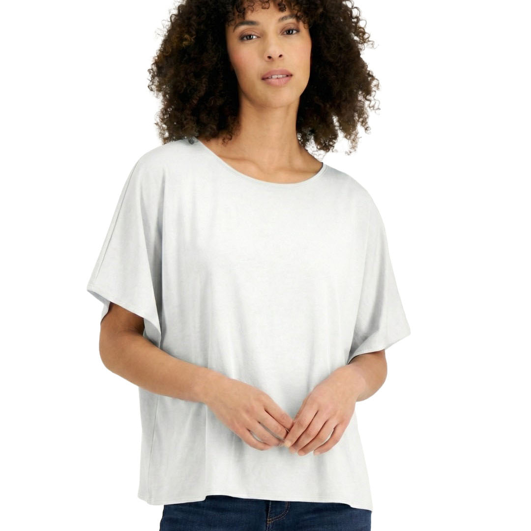 Woman wearing a white oversized t-shirt and blue jeans on a white background