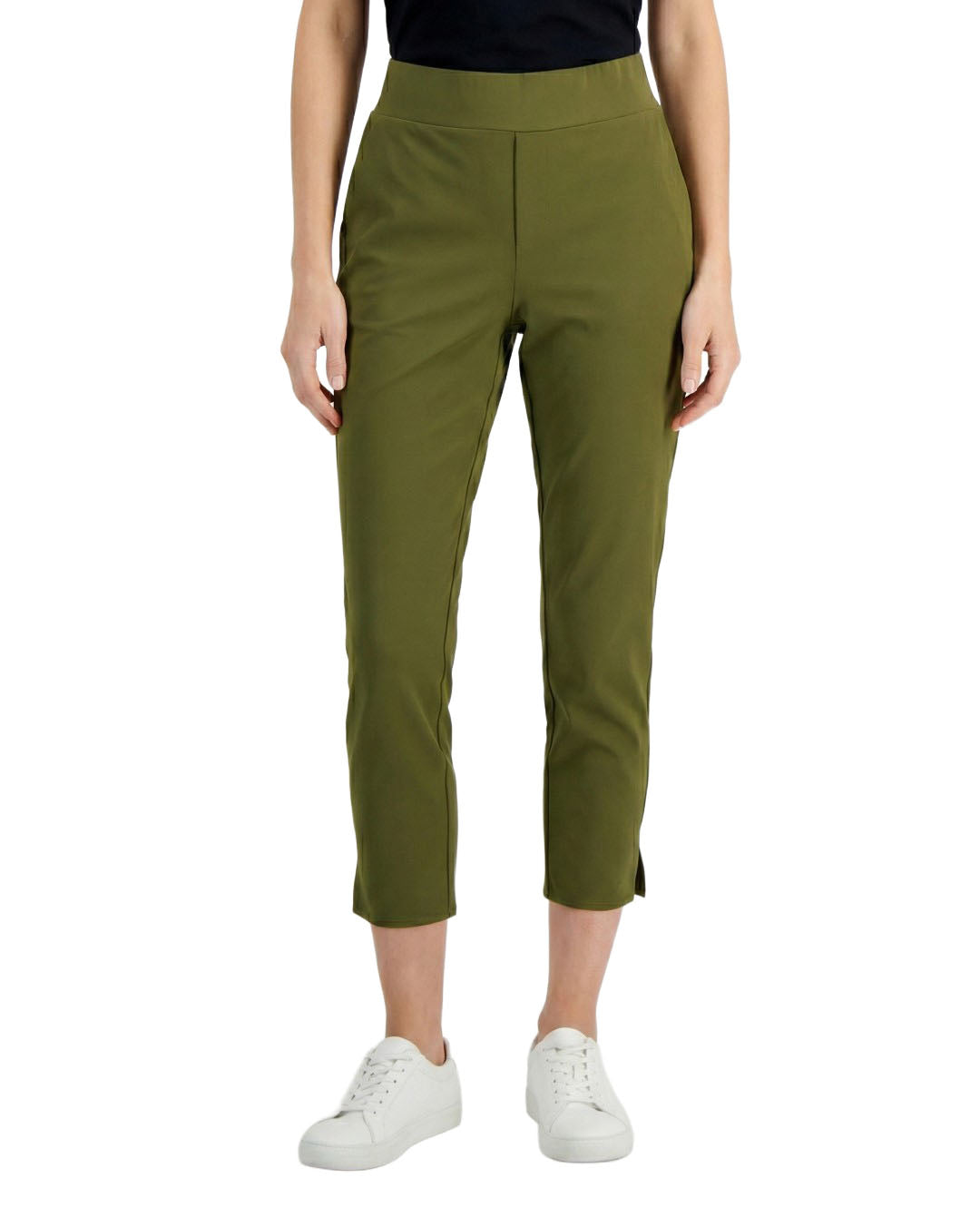 Person wearing green pants and white sneakers on a white background