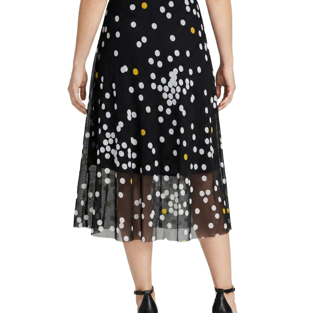 Black skirt with white and yellow polka dots worn by a person on a white background
