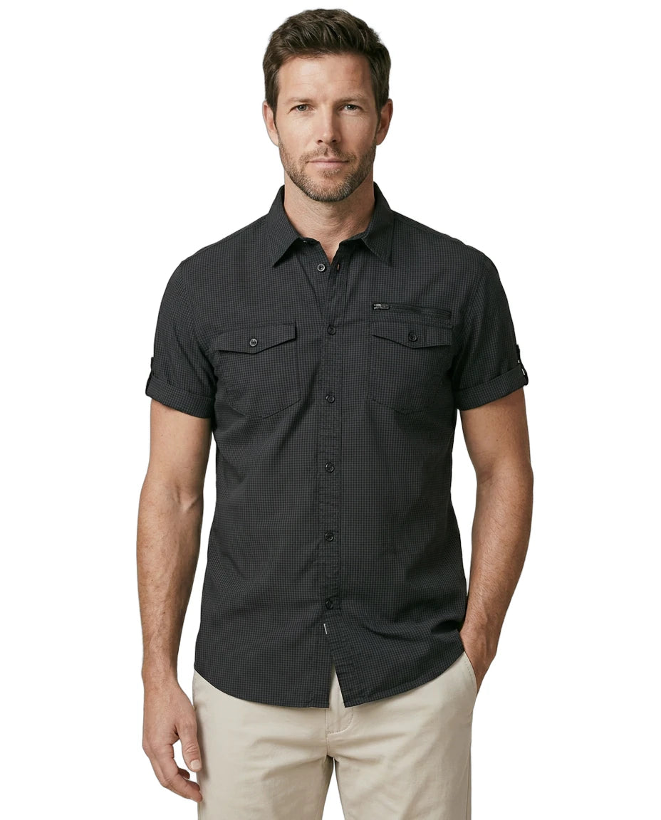 Man wearing a black short-sleeve shirt with pockets on a white background