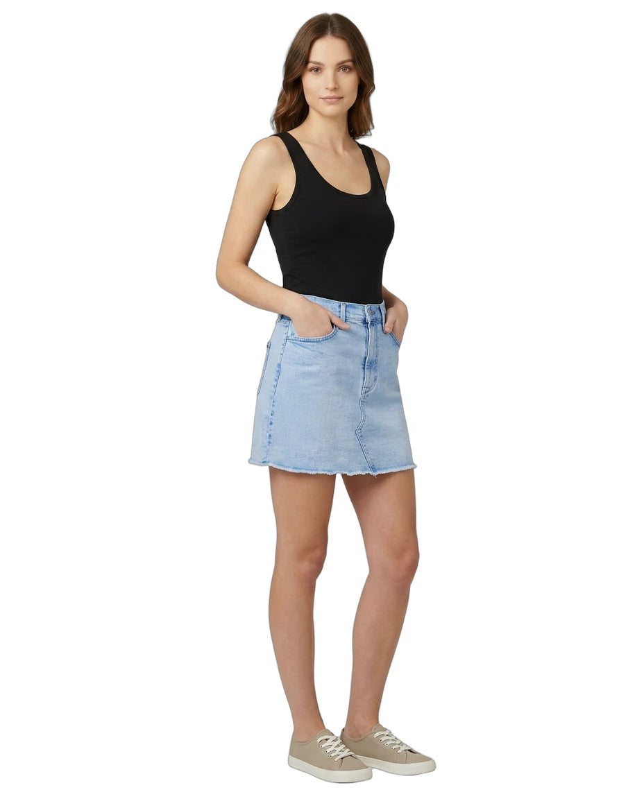 Woman wearing a black tank top and light blue denim skirt on a white background