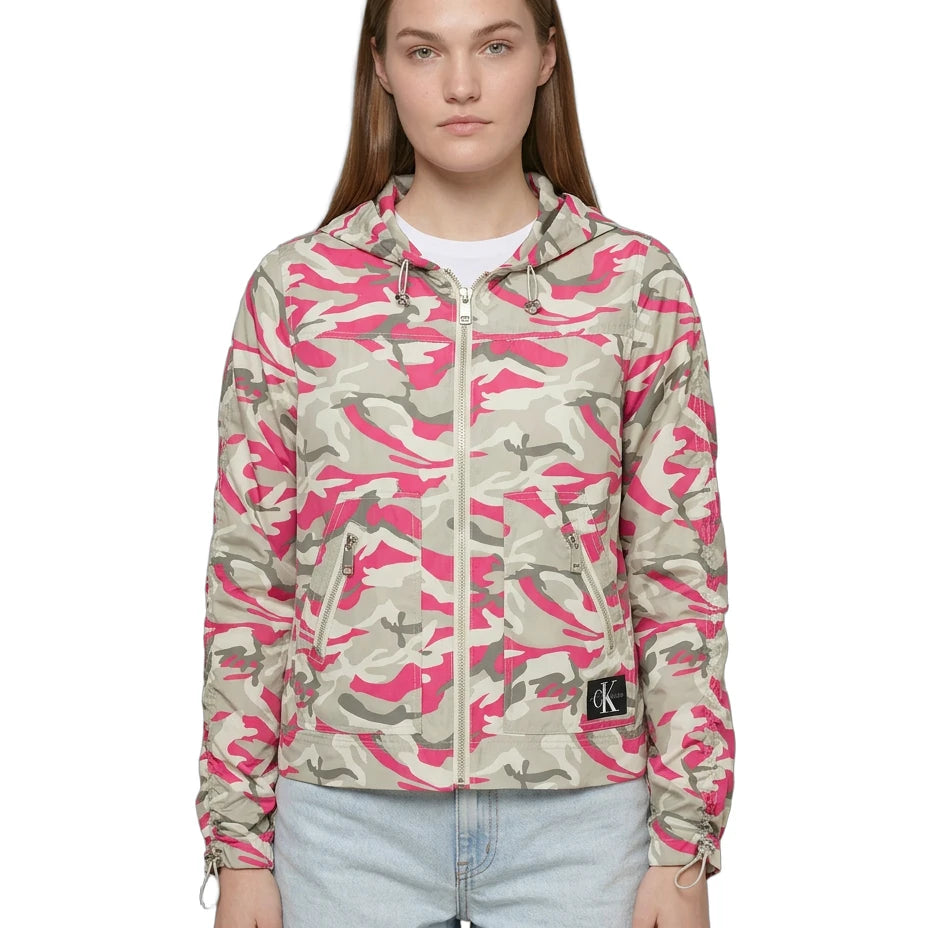 Person wearing a pink and beige camouflage jacket with a brand logo on a white background