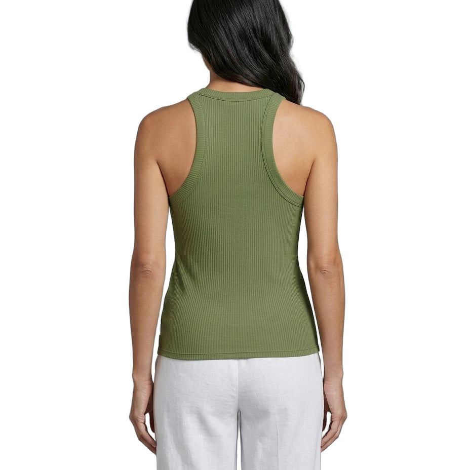 Woman wearing a green tank top and white pants on a white background