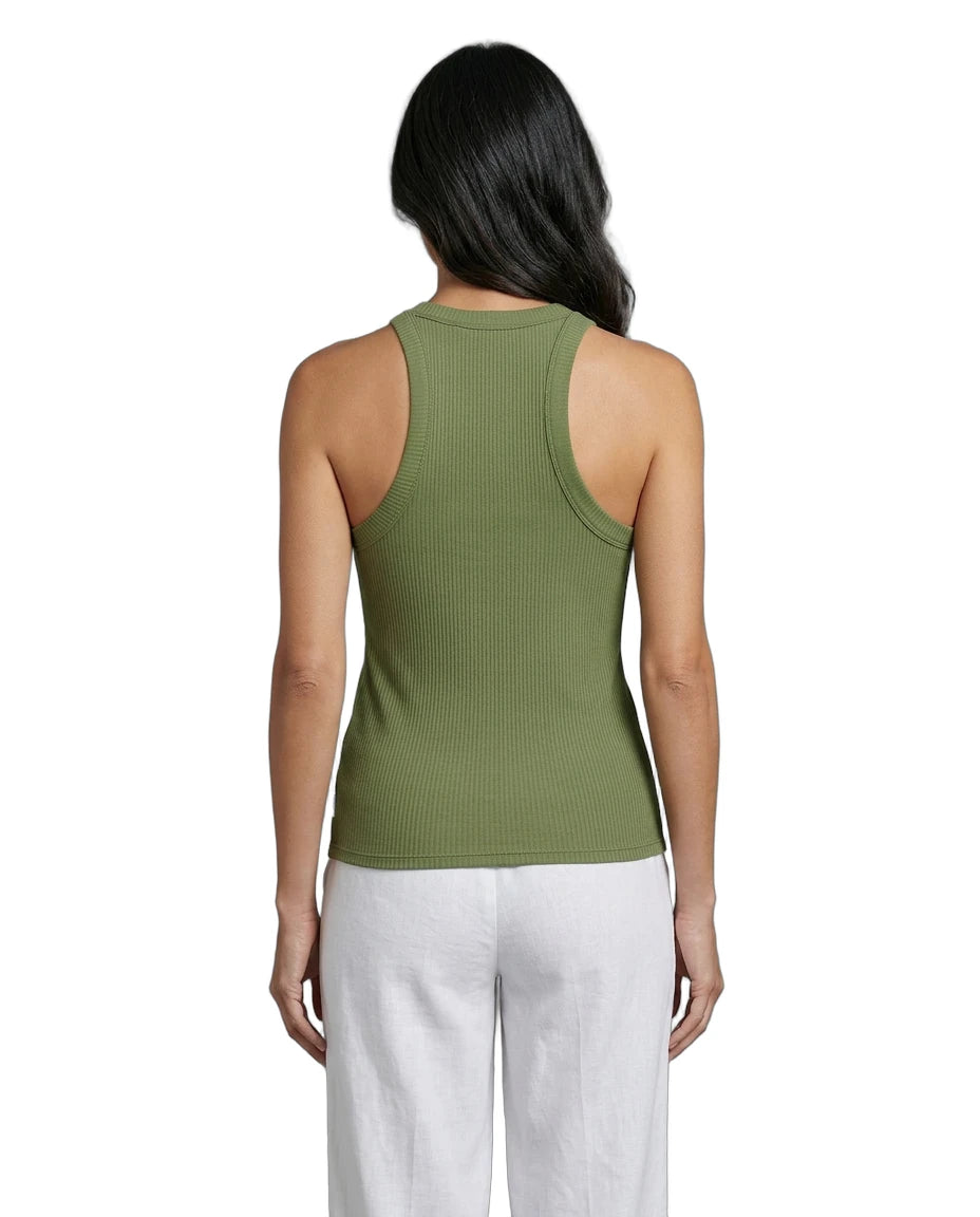 Woman wearing a green tank top and white pants on a white background