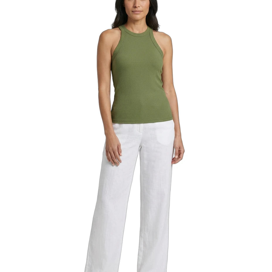 Woman wearing a green sleeveless top and white pants on a white background
