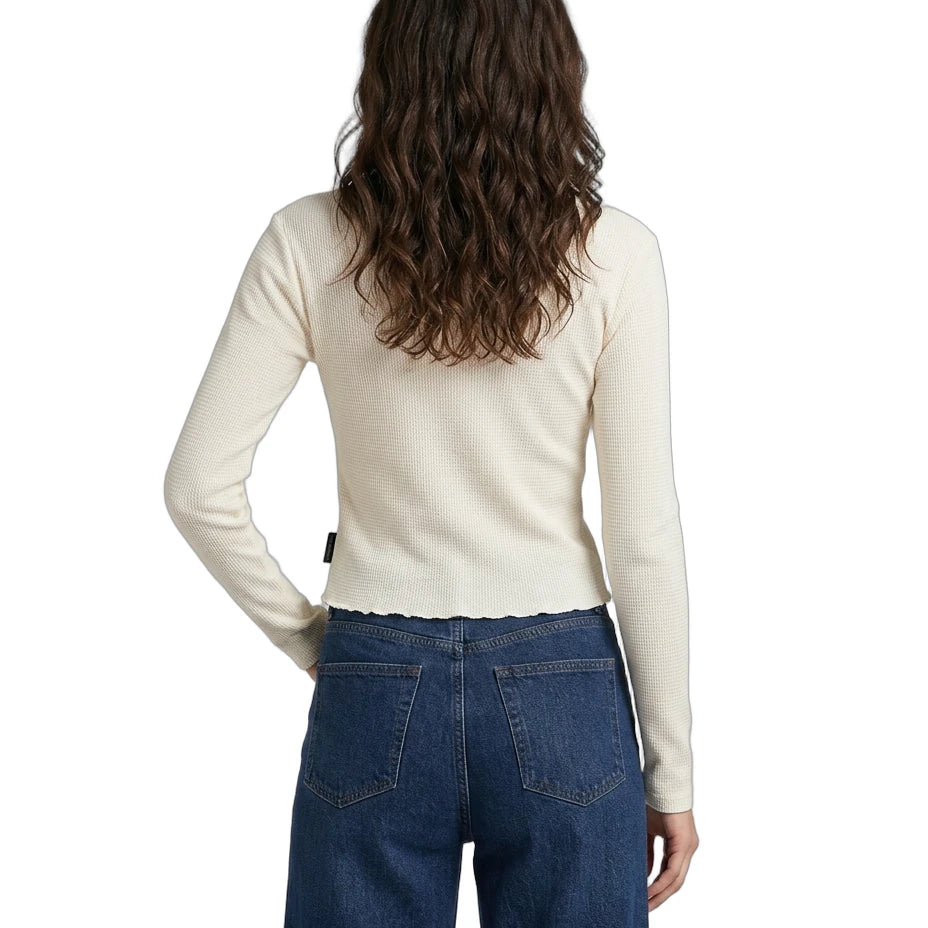 Person wearing a cream sweater and blue jeans on a white background