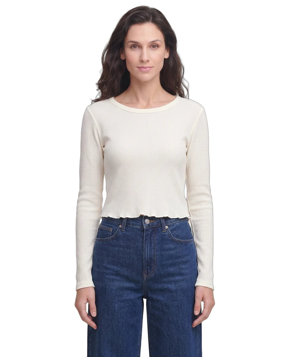 Woman wearing a white long-sleeve top and blue jeans on a white background