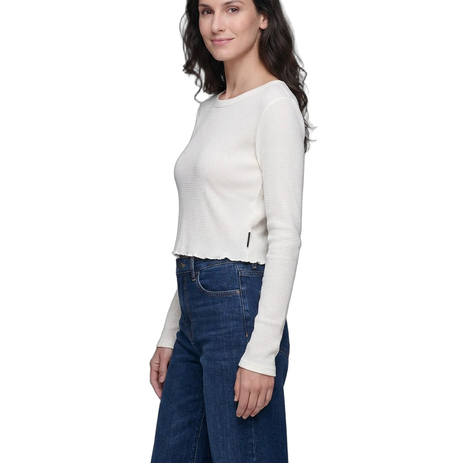 Woman wearing a white long-sleeve top and blue jeans on a white background