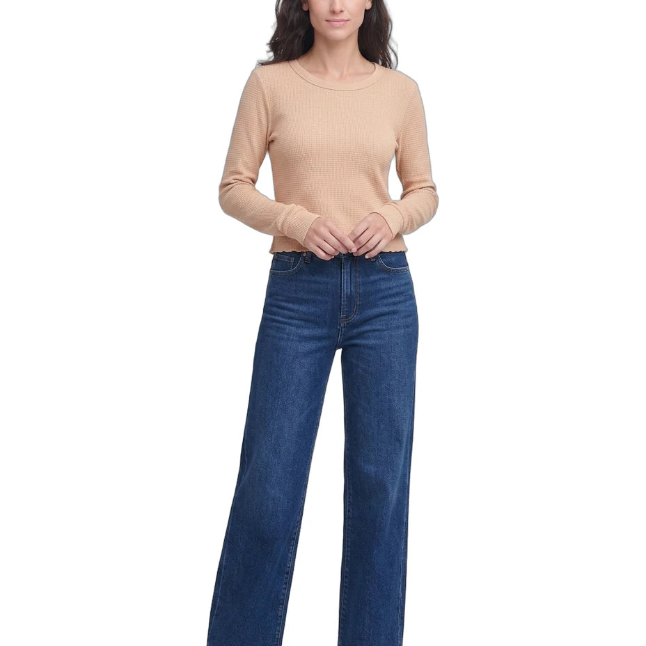 Woman wearing a beige sweater and blue jeans on a white background