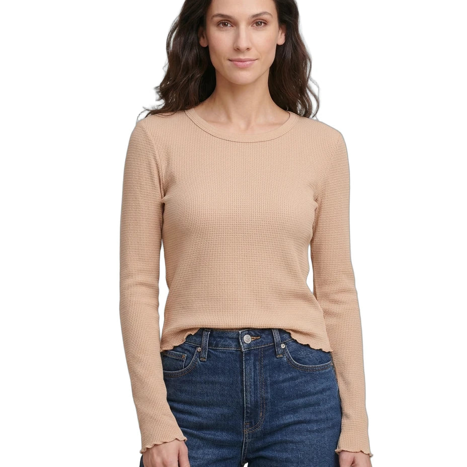 Woman wearing a beige long-sleeve top and blue jeans on a white background