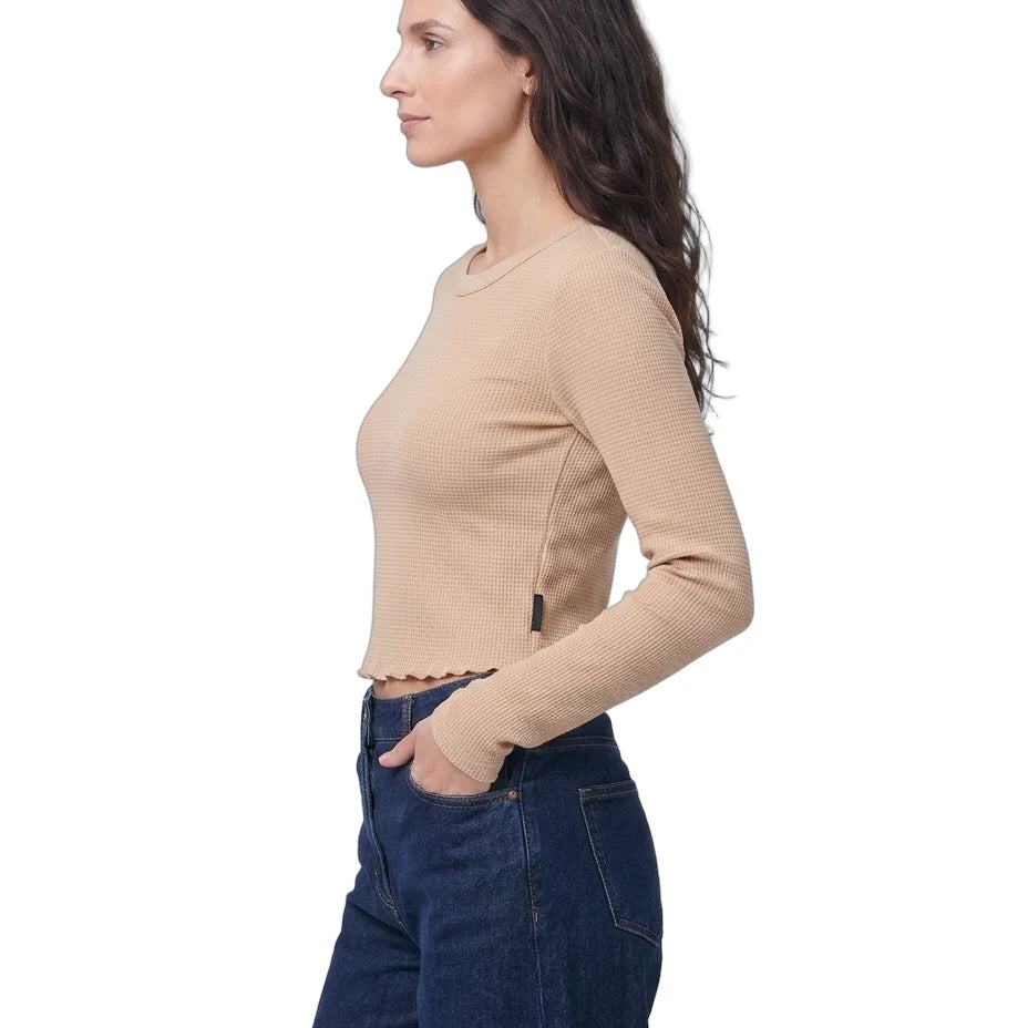 Woman wearing a beige sweater and blue jeans on a white background