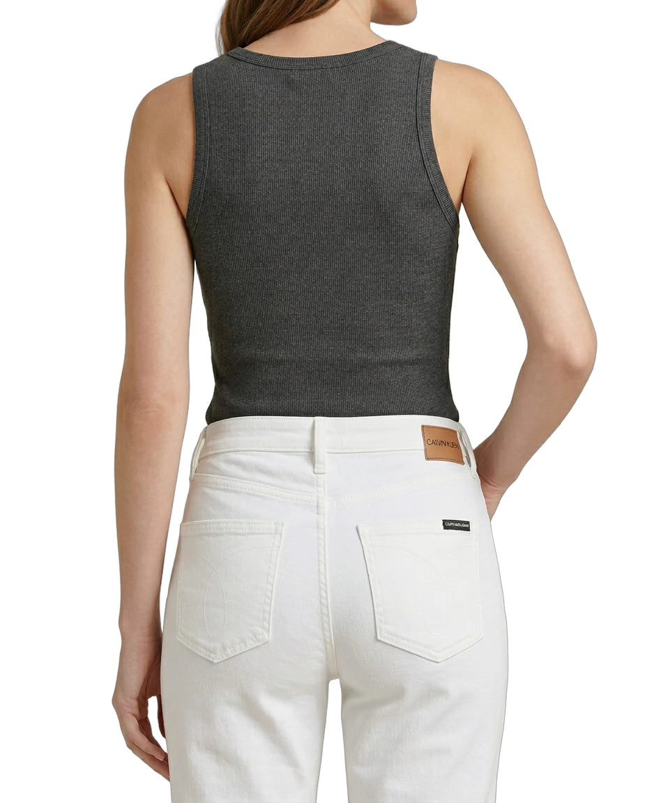 Person wearing a gray tank top and white pants on a white background