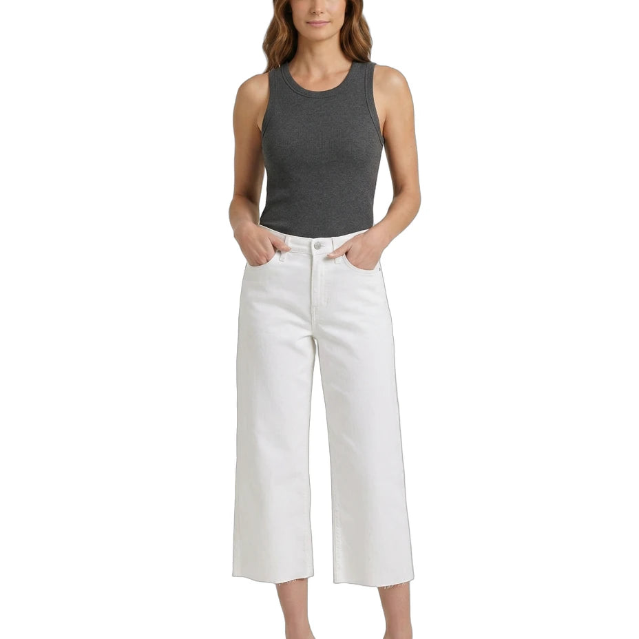 Woman wearing a gray tank top and white pants on a white background