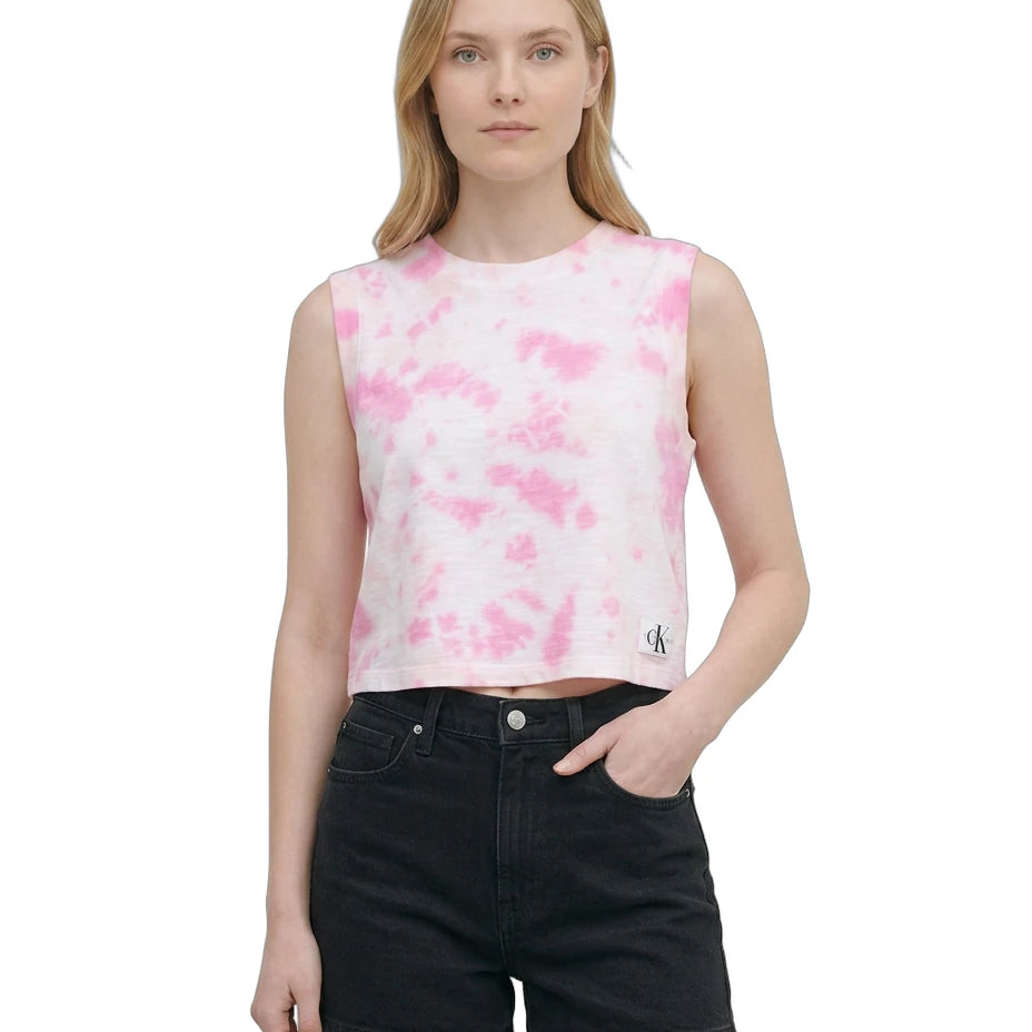 Woman wearing a pink tie-dye sleeveless top and black shorts on a white background