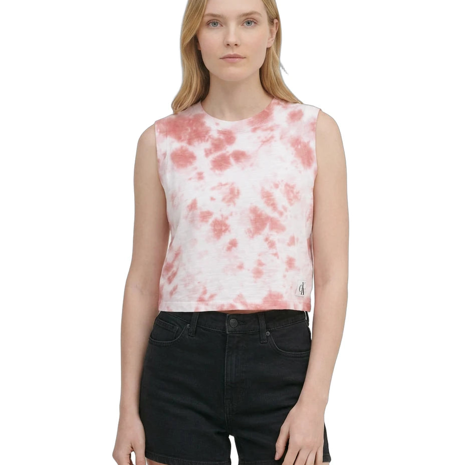 Woman wearing a sleeveless pink and white tie-dye top with black shorts on a white background