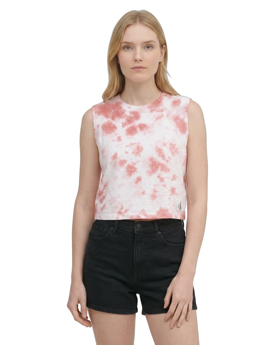 Woman wearing a sleeveless pink and white tie-dye top with black shorts on a white background