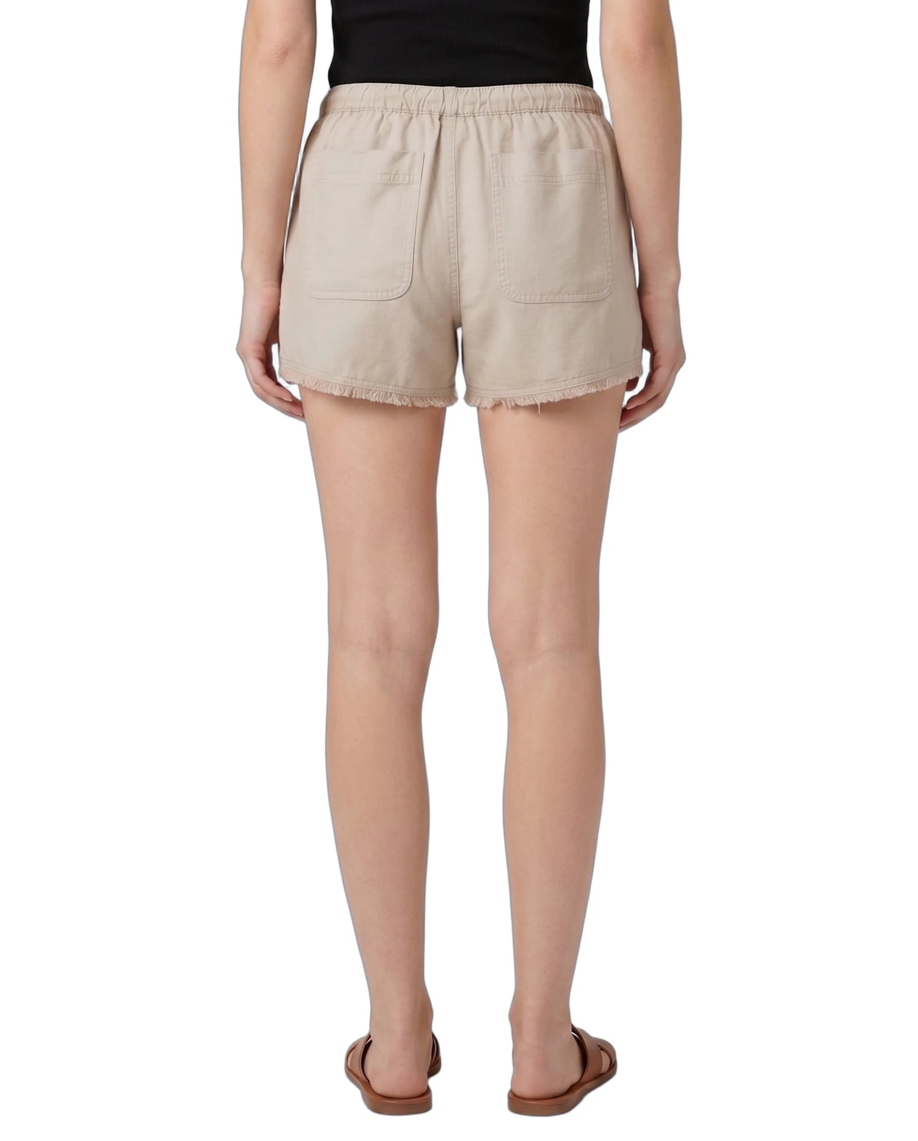 Beige shorts worn by a person on a white background