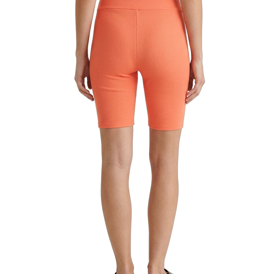 Person wearing bright orange shorts on a white background