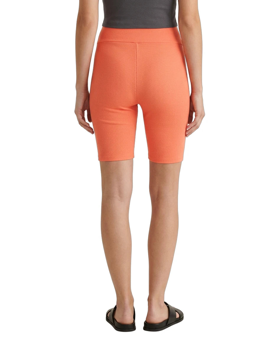 Person wearing bright orange shorts on a white background