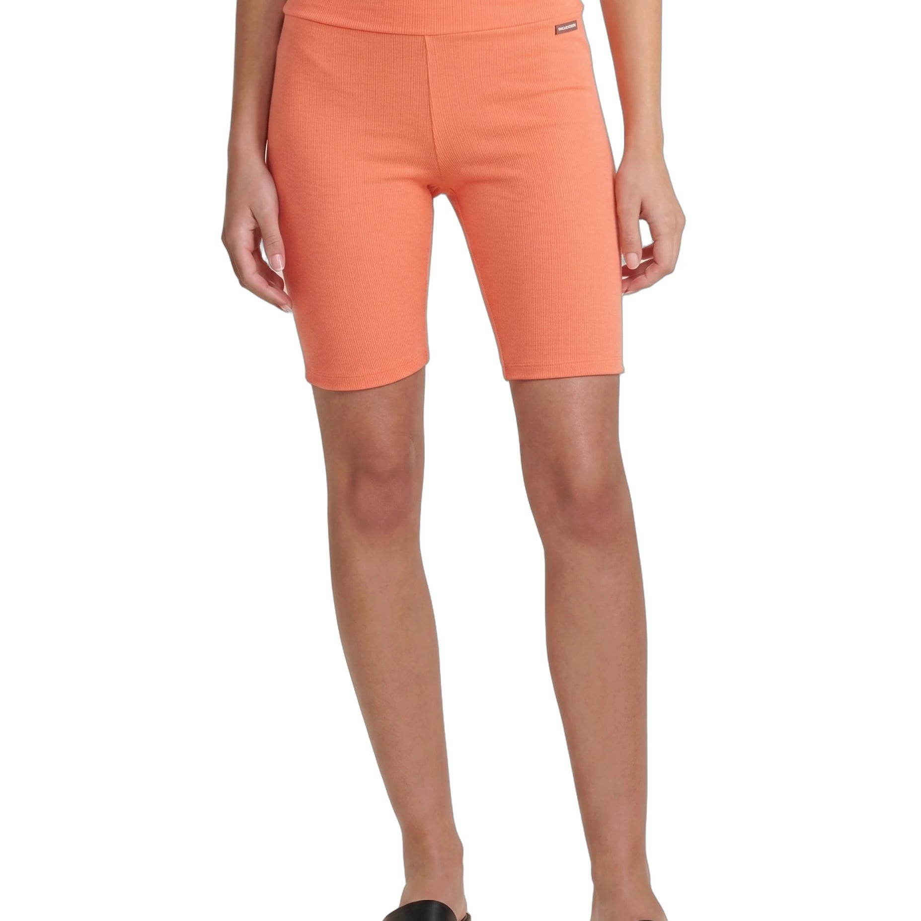 Person wearing orange shorts on a white background
