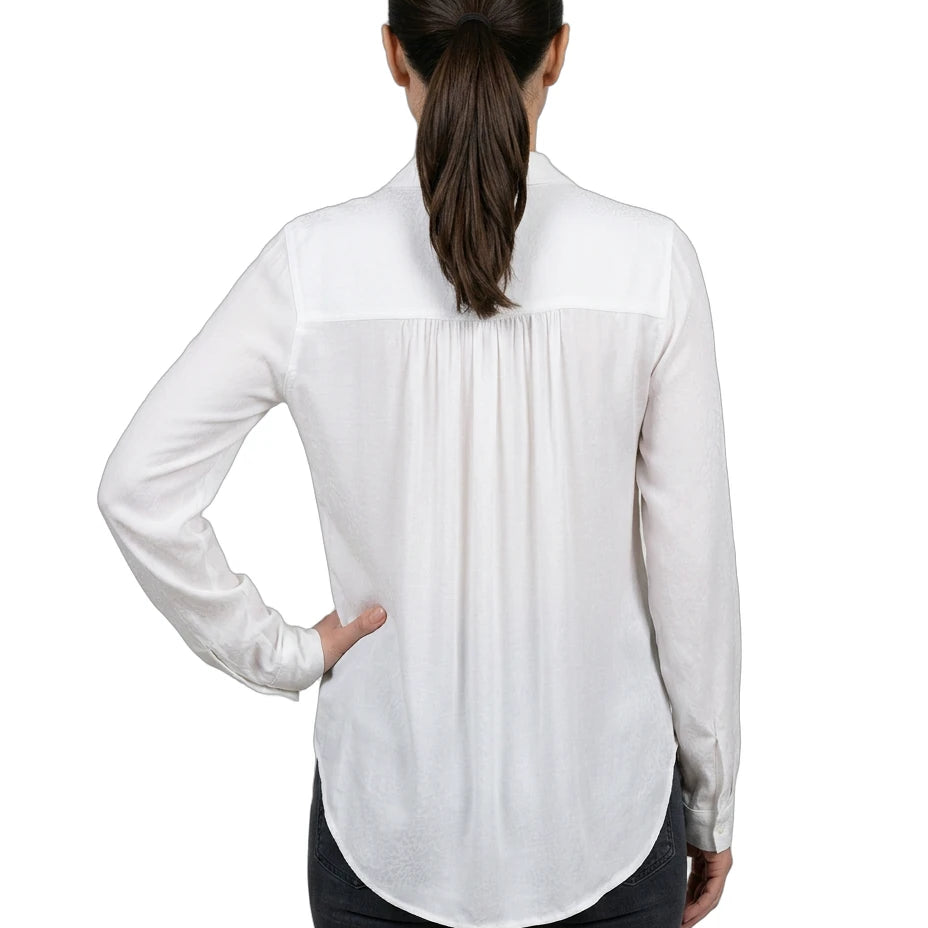 Woman wearing a white blouse with a subtle pattern on a white background