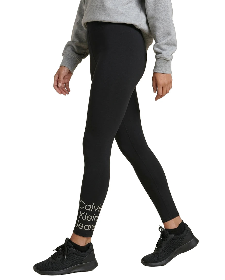 Person wearing black Calvin Klein leggings on a white background