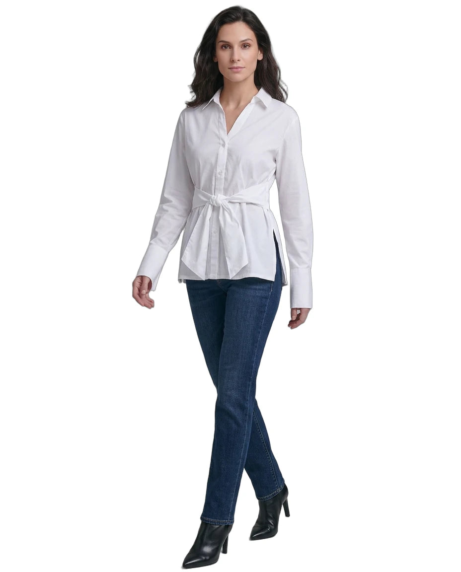 Woman wearing a Calvin Klein white blouse with a belt and blue jeans on a white background