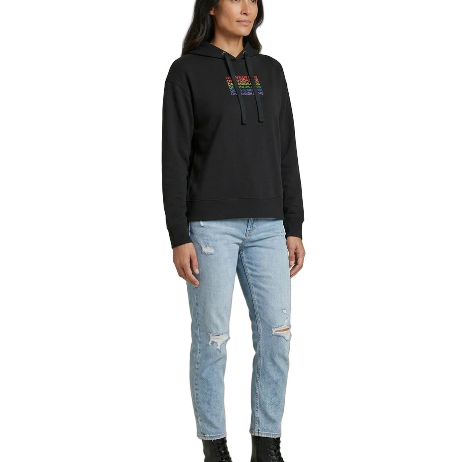Woman wearing a black Calvin Klein hoodie with colorful text design on a white background