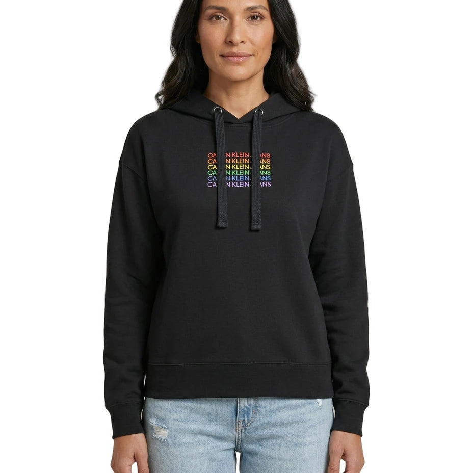 Person wearing a black Calvin Klein hoodie with colorful text design on a white background