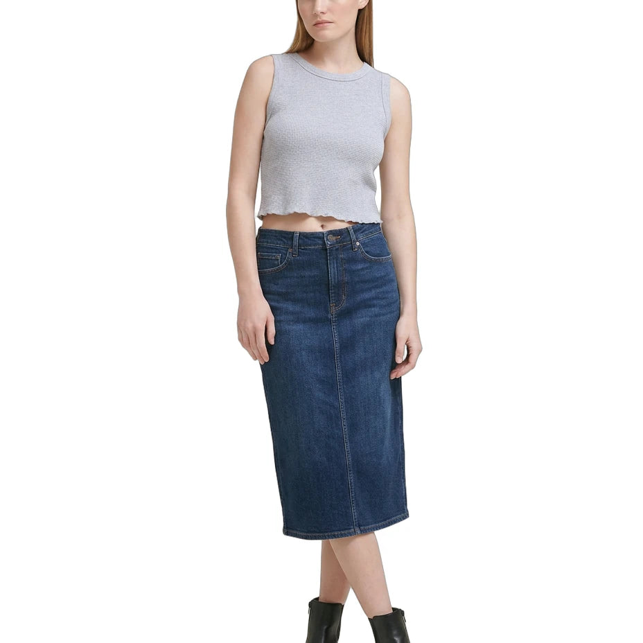 Woman wearing a gray sleeveless Calvin Klein top and blue denim skirt on a white background