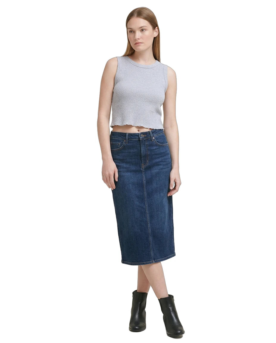 Woman wearing a gray sleeveless Calvin Klein top and blue denim skirt on a white background