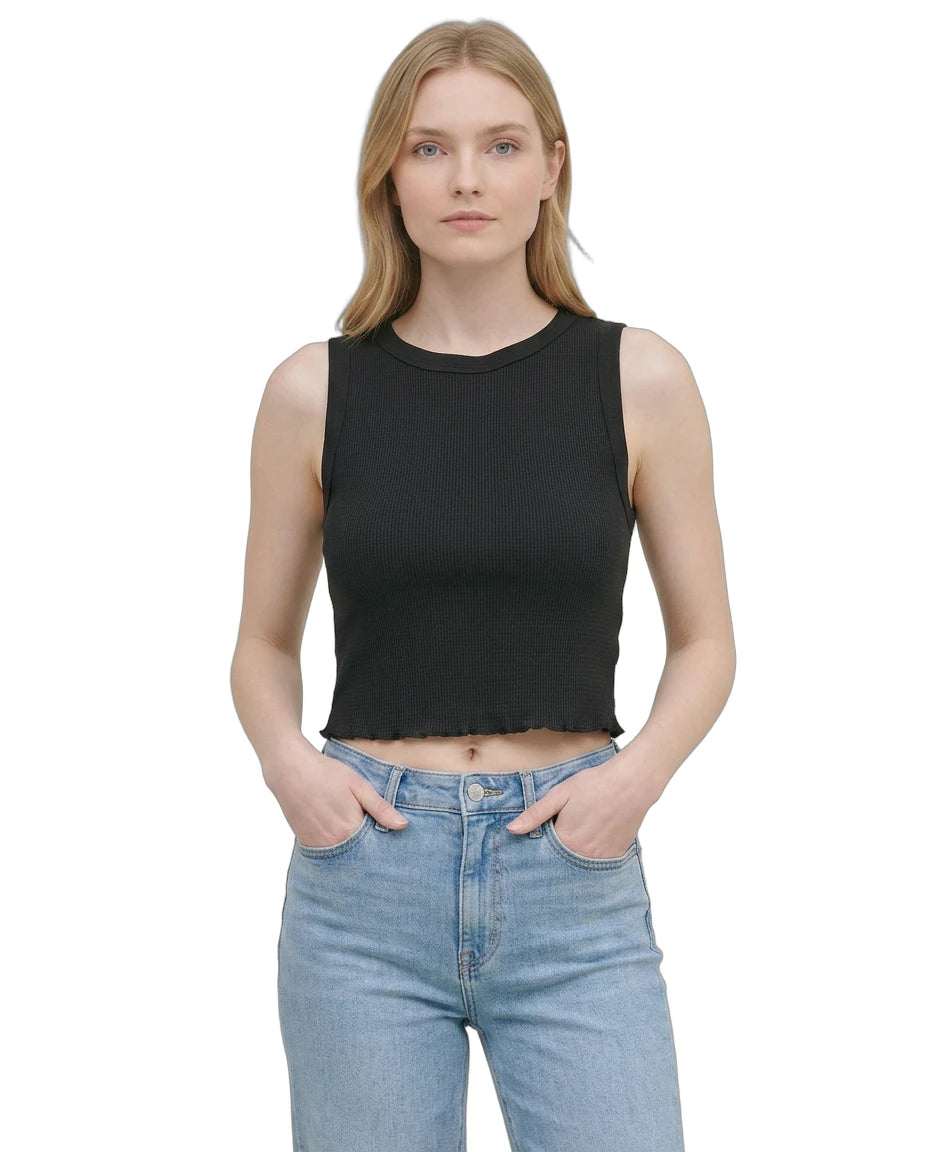 Woman wearing a black sleeveless top and blue jeans on a white background
