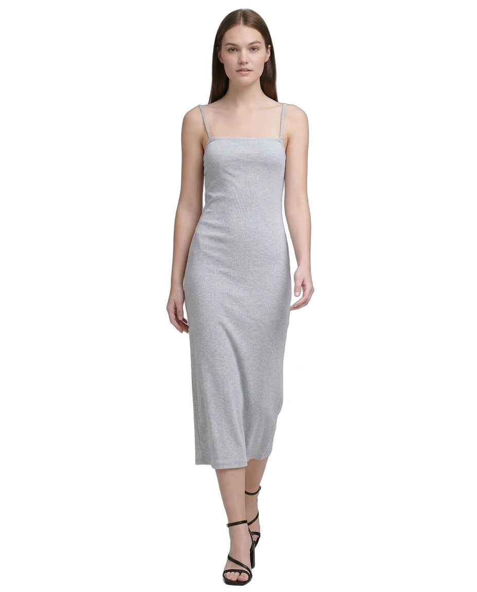 Woman wearing a light gray Calvin Klein dress on a white background